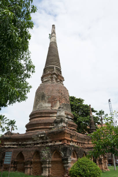 Ancient stone pagoda beside plants stock photo