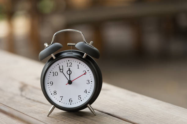 istock Retro alarm clock with five minutes to twelve o'clock. 864831700