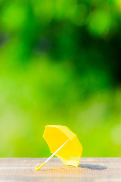 istock Yellow umbrella and green blur background 864858492