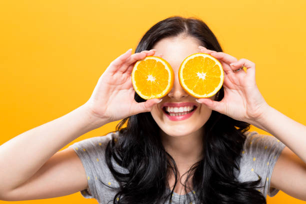 istock Happy young woman holding oranges 864865520