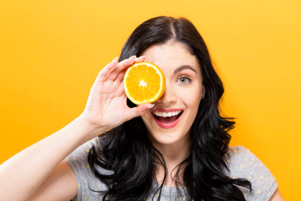 istock Happy young woman holding oranges 864865546