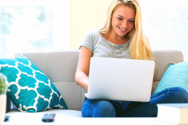 istock Young woman using her laptop in on her couch 864865568