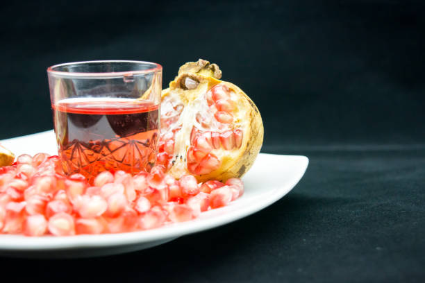 istock open pomegranade composition with a glass full of pomegranade juice 864866028
