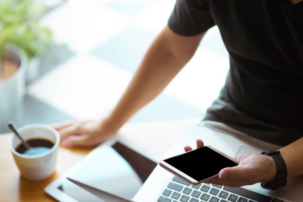 istock Smartphone in young man hand with digital tablet and coffee , selective focusing . 864866110