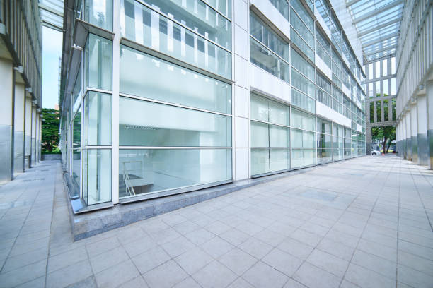 istock Modern empty office buildings with glass wall and empty pavement . 864866192