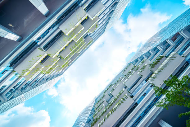 istock Low angle perspective view of modern office building with green eco concept balcony . 864866228