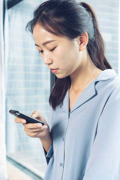 istock woman texting messages,leaning by window sill 864866262