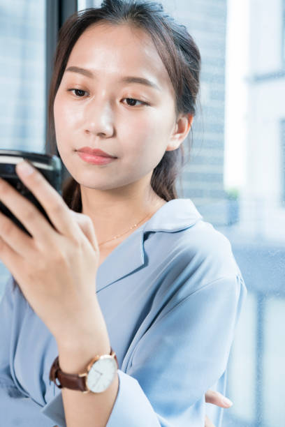 istock woman texting messages,leaning by window sill 864866486