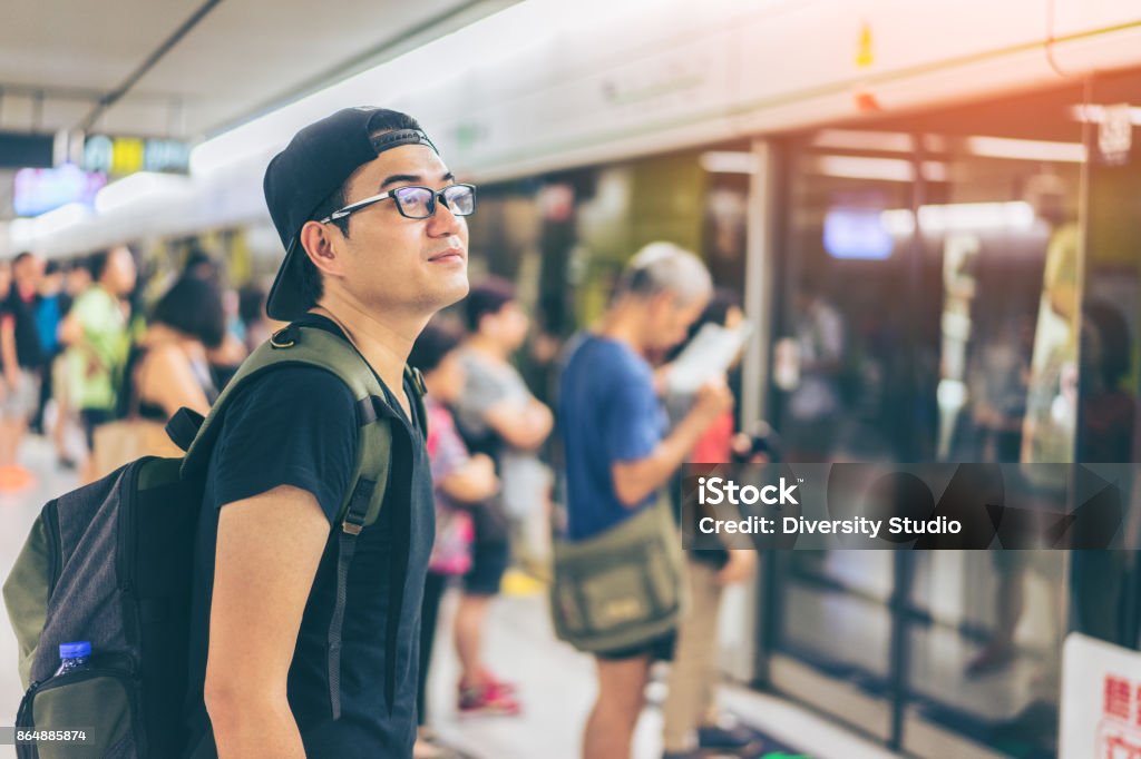 Young asian traveler waiting for transportation underground at Hong Kong MTR Hong Kong Stock Photo
