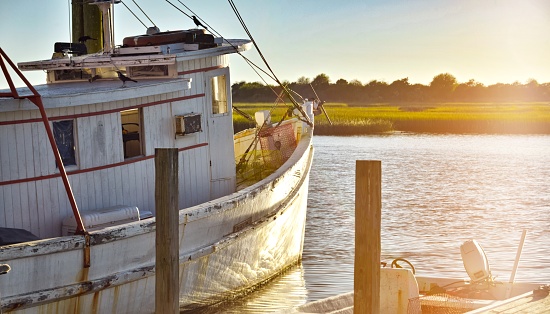 A shrimp boat sits moored in a fishing village.