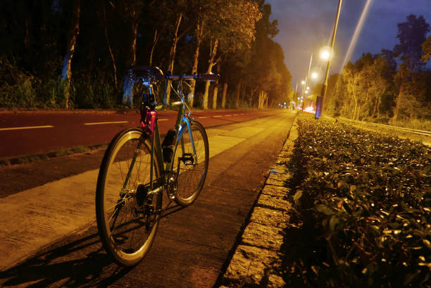 The retro parked bicycle near the road at night