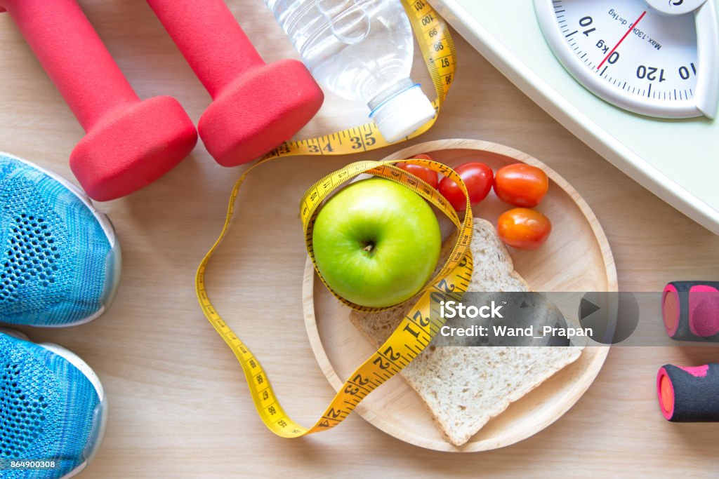 Green apple and Weight scale,measure tap with clean water and sport equipment for women diet slimming.  Diet and Healthy Concept Dieting Stock Photo