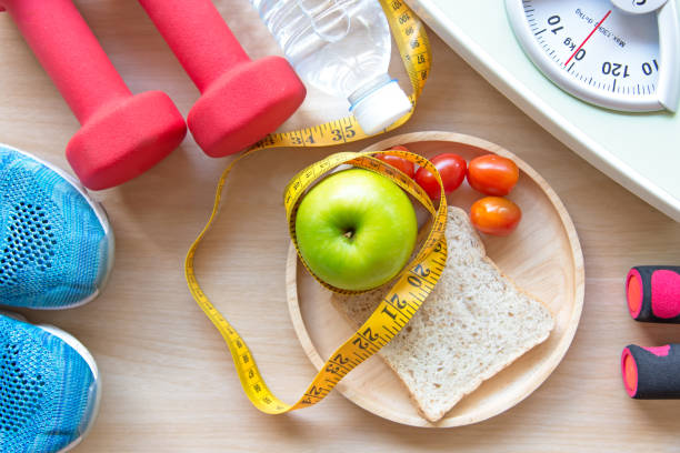 maçã verde e escala de peso, medir a torneira com água limpa e equipamento do esporte para mulheres dieta de emagrecimento.  dieta e conceito saudável - dieting healthy eating healthy lifestyle tape measure - fotografias e filmes do acervo