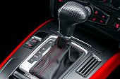 Automatic gear stick with red stich of a modern car. Car interior details. Dashboard with buttons