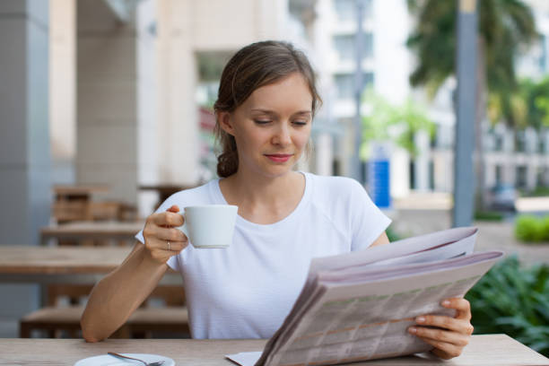 istock Content Lady Drinking Coffee and Reading Newspaper 864912162
