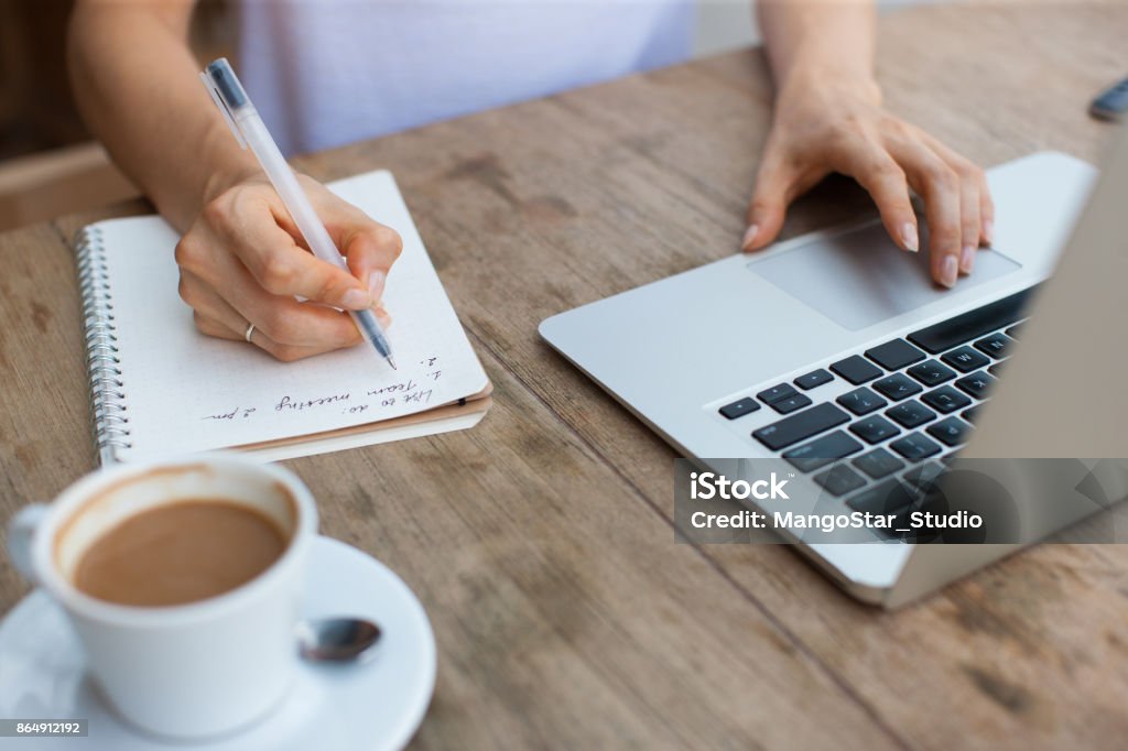 Recorta la vista de la mujer que trabaja en la computadora portátil en Cafe - Foto de stock de Lista libre de derechos