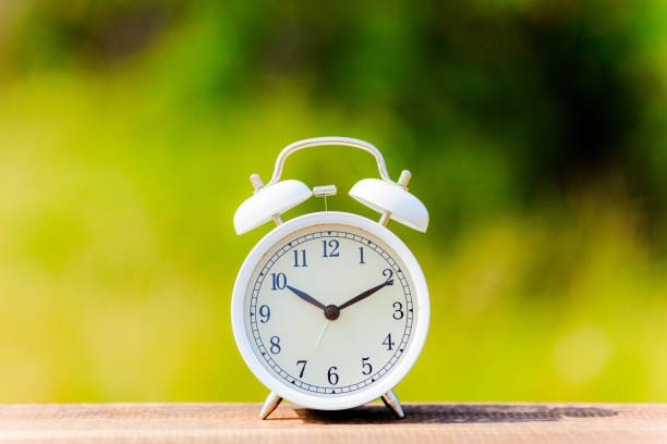 istock Alarm clock and green blur background 864912490