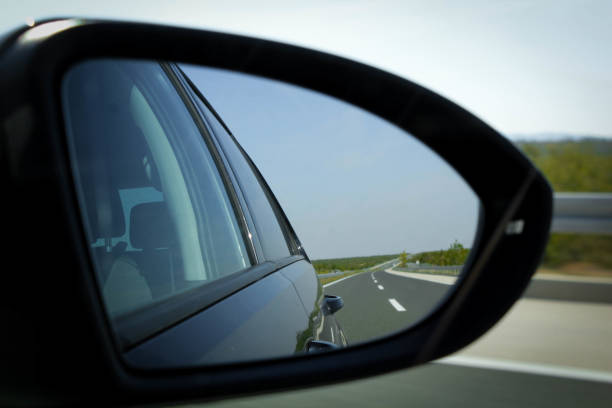 istock Rear view on a car mirror reflecting road 864915160