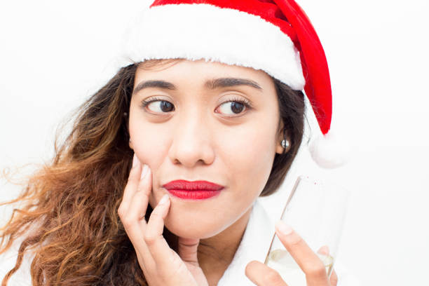 primer plano de mujer pensativa con sombrero de santa con la flauta - women gripping sadness party fotografías e imágenes de stock