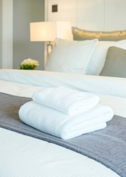 White towels on bed in modern bedroom interior stock photo