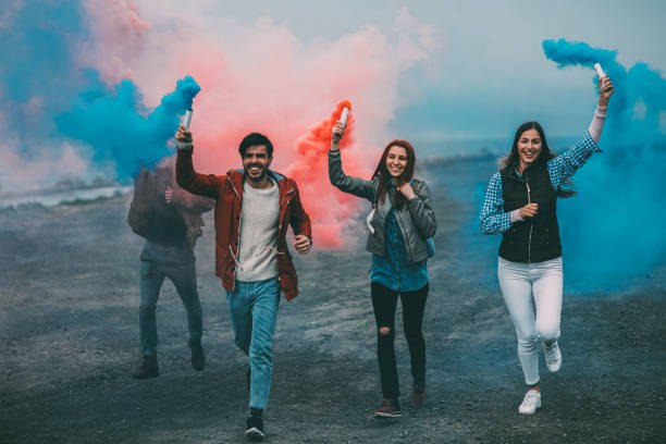istock Friends running with smoke bombs in their hands 864925954