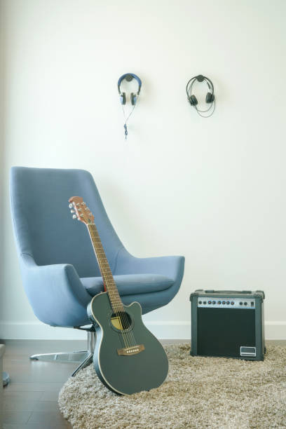 studio de musique avec fauteuil gris, guitare et casque - armchair comfortable relaxation headphones photos et images de collection