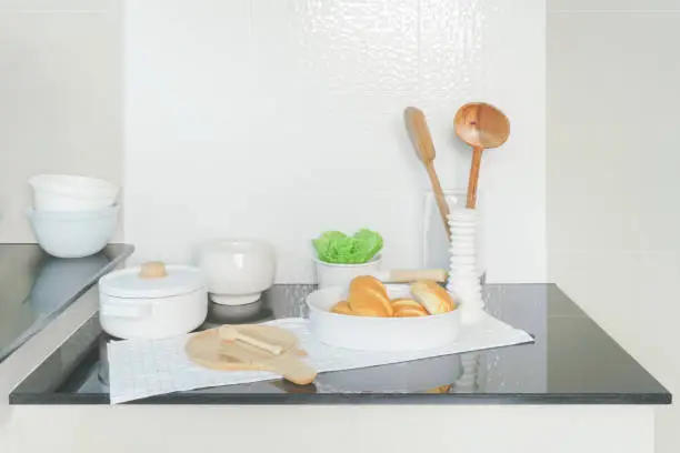 Tray of bread  and white ceramicware on black counter top in the kitchen