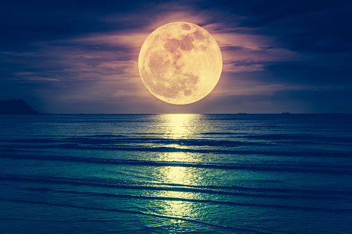 Super Luna. Linterna colorida del cielo con nubes y brillante luna llena sobre el paisaje marino. photo