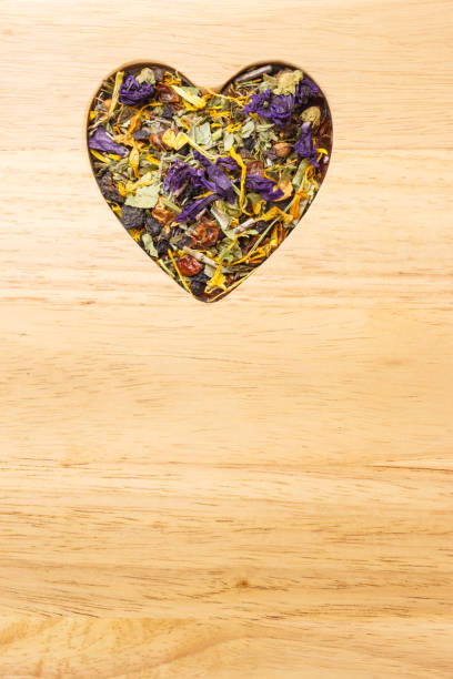 istock Dried herb leaves heart shaped on wooden surface 864950576