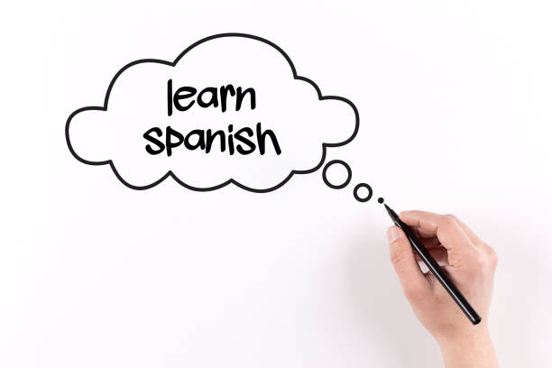 istock Hand writing LEARN SPANISH on white paper, View from above 864954740