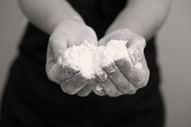 Whole wheat flour on palm of young woman, close up.