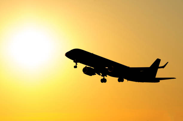 istock Commercial airplane taking off against orange sunset background 864983204