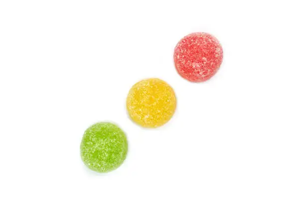 Red, yellow and green jellybean candy seen from top isolated on white background