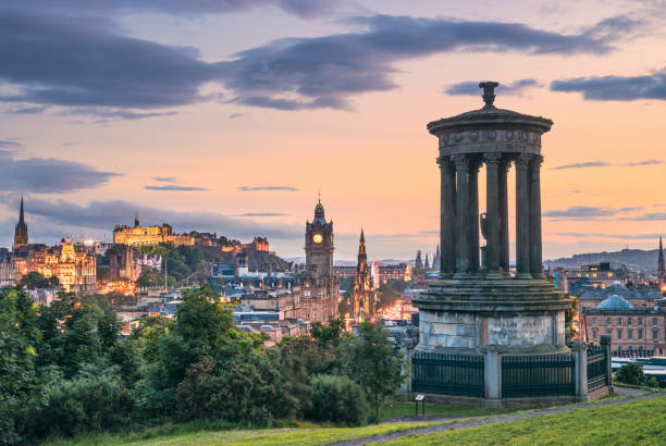 Looking over the buildings and roofs of Edinburgh Old Town towards Edinburgh Castle from Calton Hill as the sun sets.