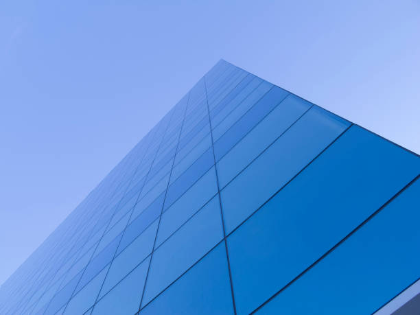 istock Anlged view of a diagonal glass facade, deep blue sky at background 865010396
