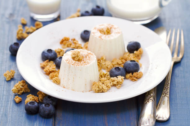 istock fresh cheese with granola and blueberries on plate on blue wooden background 865014702