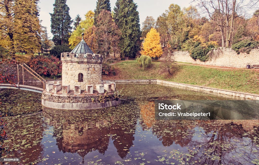 Turret in Bojnice, Slovakia, autumn park, red filter Turret in Bojnice, autumn park, lake and colorful trees. Slovak republic. Seasonal natural scene with beautiful pond. Red photo filter. Ancient Stock Photo