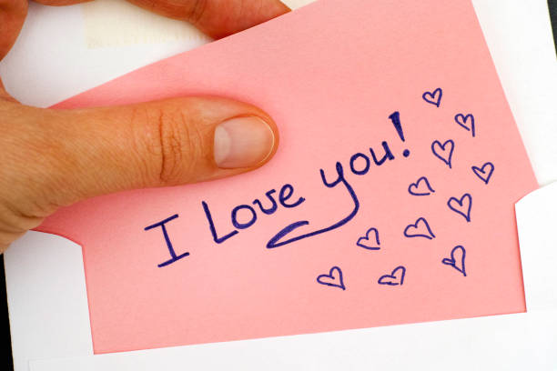 istock Woman hand taking out letter with text I Love You! from envelope. 865016398