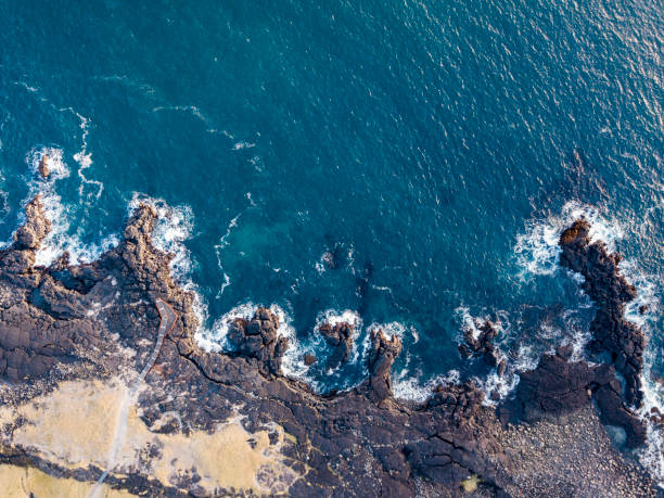 istock Waves splashing against volcanic rocks 865016790