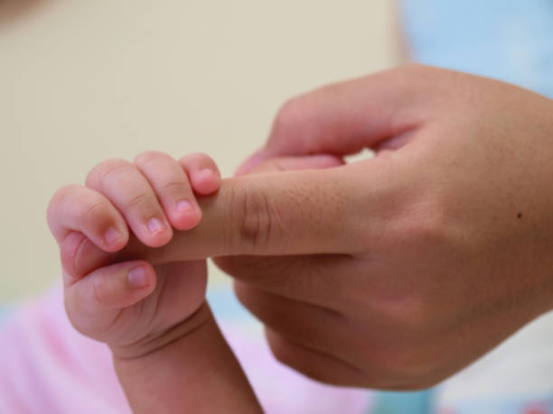 istock The baby hand catch her mother finger 865022800