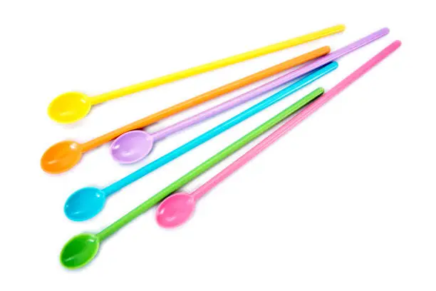 Colorful long plastic spoons isolated on white background