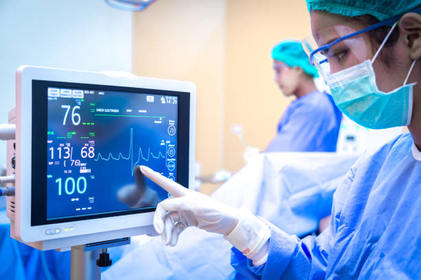 Female surgeon using monitor in operating room. Female surgeon using monitor in operating room. anaesthetist stock pictures, royalty-free photos & images