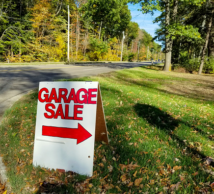 garage sale in grass on street curb with autumn trees background