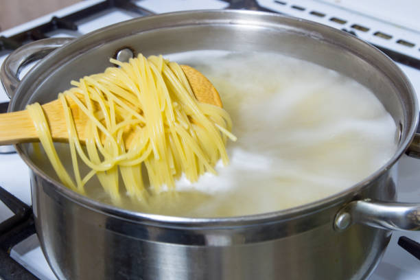 istock Spaghetti cooked in boiling water on a gas stove. 865035952