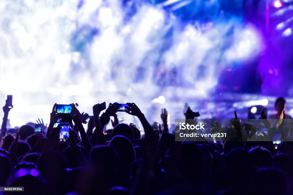 Hand with a smartphone records live music festival Hand with a smartphone records live music festival, Taking photo of concert stage, live concert, music festival, happy youth, luxury party, landscape exterior Greece Stock Photo