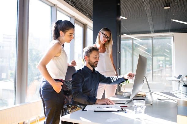 Three business people in the office working together.
