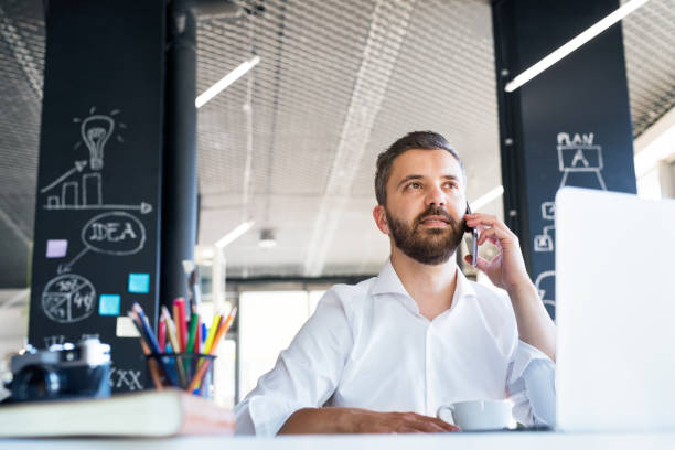 istock Businessman with smartphone and coffee in his office. 865043022