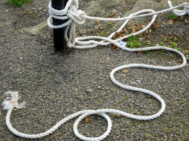 Folkestone, England - October 16, 2017: a thin, white, coiled-up rope with frayed ends looks like a snake lying on the quayside in Folkestone Harbour. Folkestone is a seaside town on the south coast.