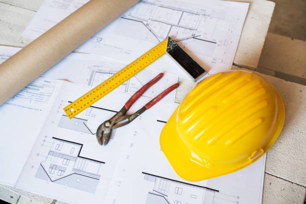 istock Pliers, square, helmet and blueprints on construction site. 865046264