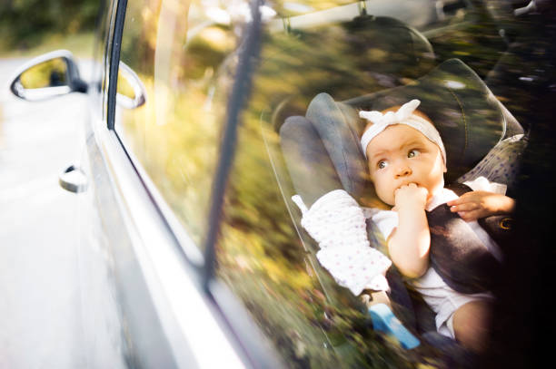 pequeño bebé sujetado con cinturón de seguridad en asiento de coche de seguridad. - finger in mouth fotografías e imágenes de stock
